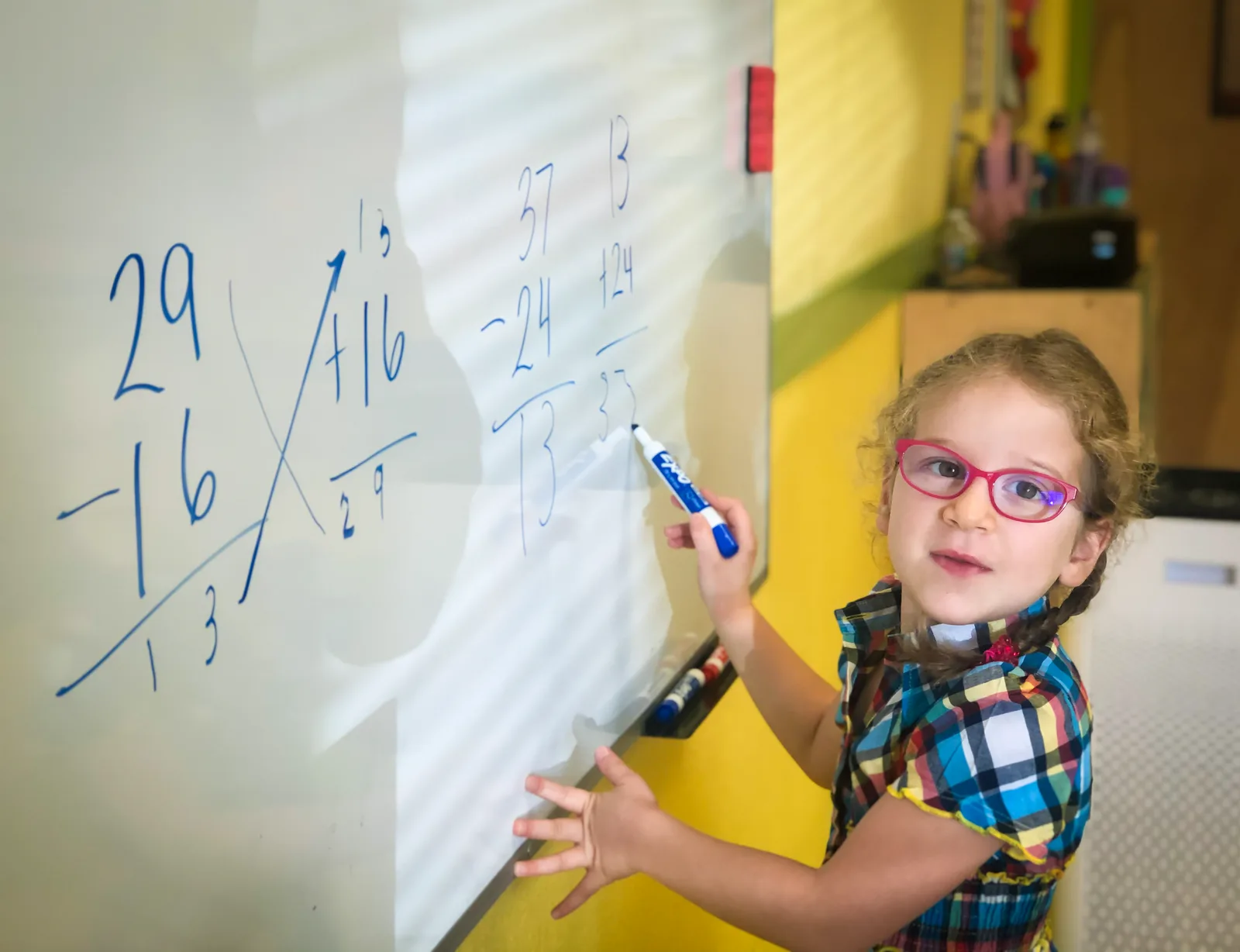 A Starbright elementary student working through a long-division problem on the classroom whiteboard