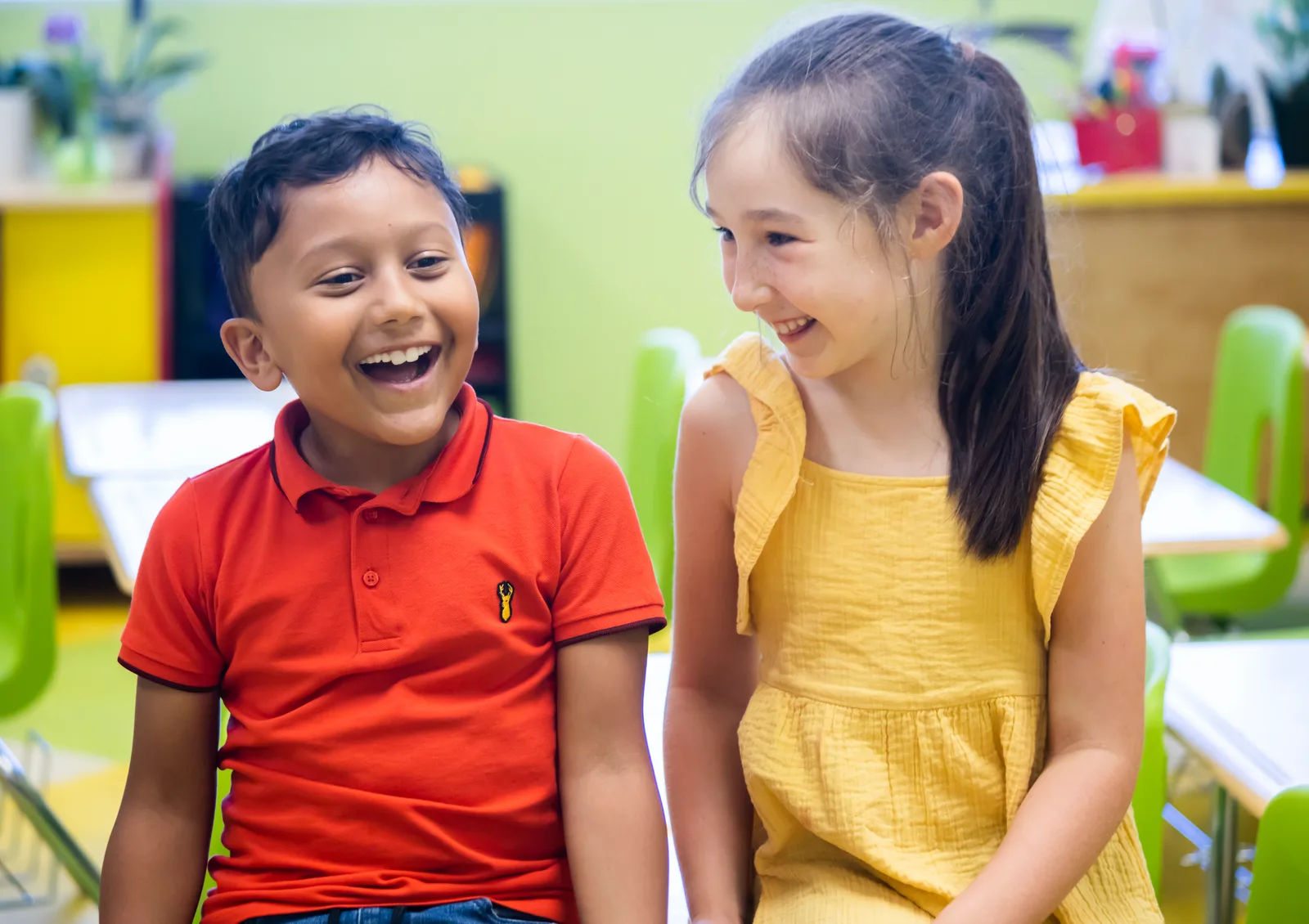 Two Starbright elementary students laughing together in class