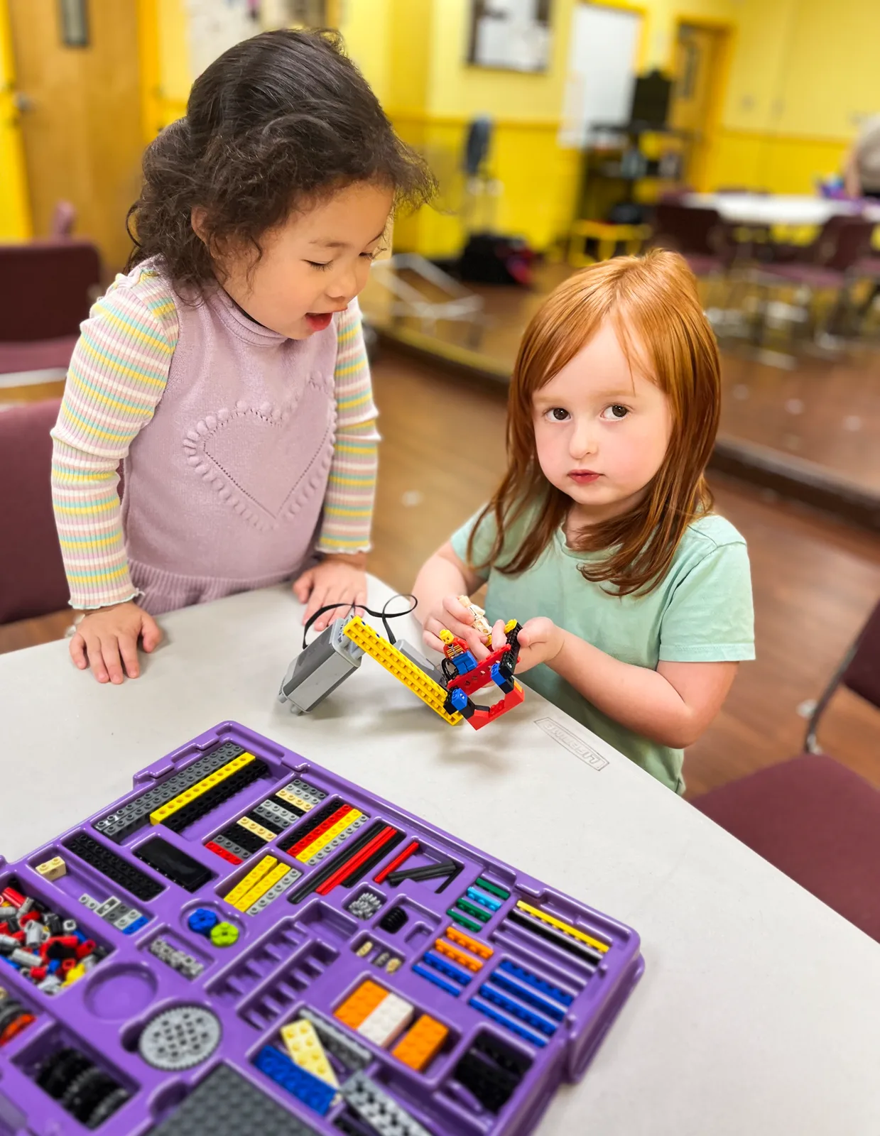 Two Starbright students building with an engineering kit at a classroom table