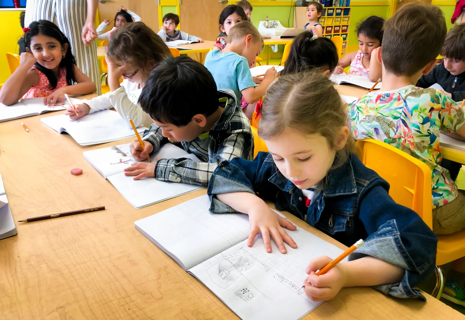 Starbright kindergarten students writing at their desks